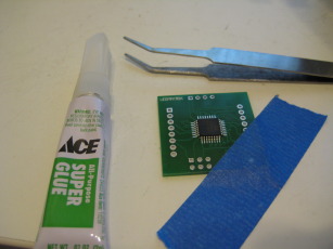 Photo of the ATMega48 affixed to the board and the tools needed.